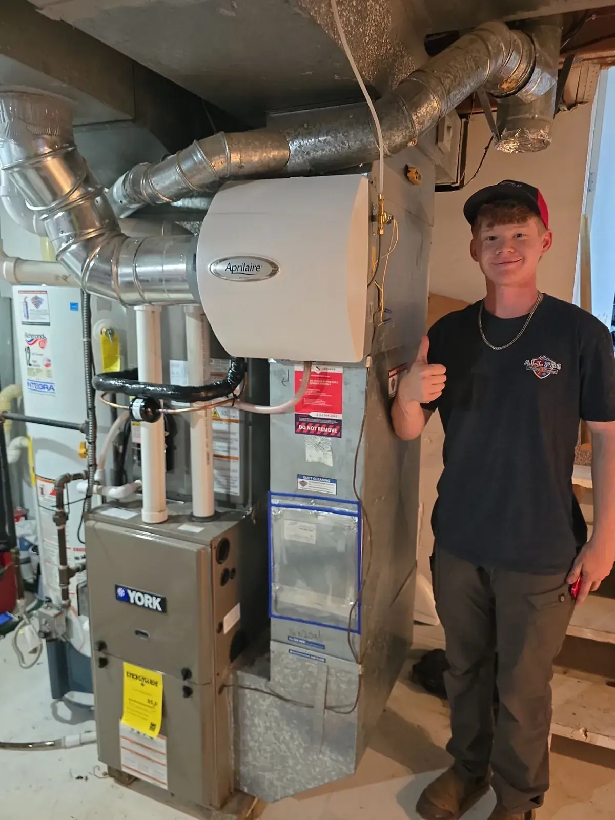 Iowa All Pro technician beside a new furnace and whole-home humidifier install