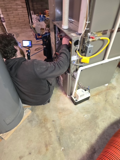 Technician repairing a Rheem furnace